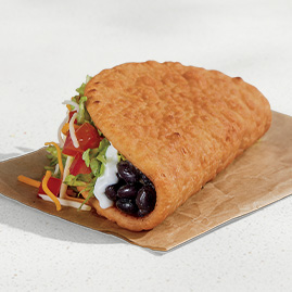 A Black Bean Chalupa Supreme® with black beans, lettuce, tomatoes, cheese, and sour cream in a crispy Chalupa shell.