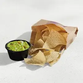 A serving of crispy tortilla chips paired with fresh, creamy guacamole.