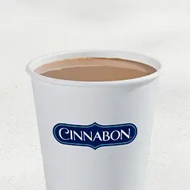 A steaming cup of Hot Cinnabon Delights® Coffee, filled with the warm flavors of cinnamon and icing.