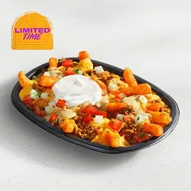 A plate of Jalapeño Ranch Nacho Fries loaded with seasoned fries, nacho cheese, beef, and a drizzle of creamy jalapeño ranch sauce.